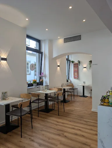 Gastraum mit Tischen und Bogendurchgang im BUTA CAFÉ